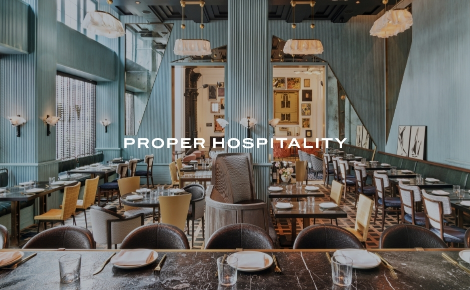 Dining room with teal walls, marble tables, and chandeliers at San Francisco Proper