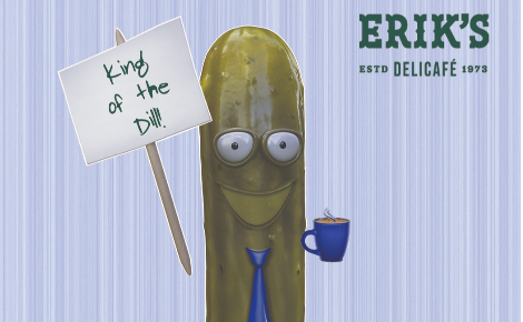 Smiling pickle with coffee mug, blue tie, and sign that says King of the Dill with light blue striped background and Erik's logo