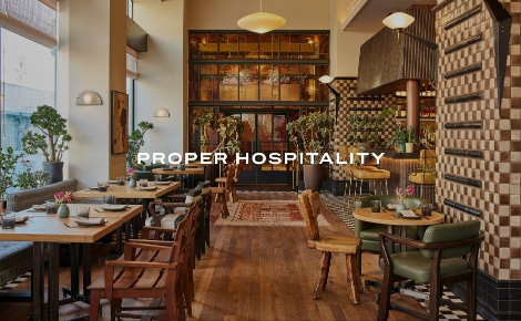 Restaurant with wood floors, patterned tiles, and green chairs at Downtown L.A. Proper