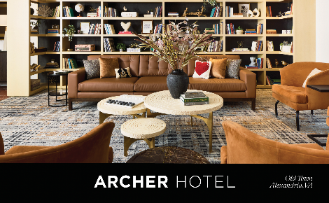 Archer Hotel Old Town Alexandria living room with seating, table and bookshelf.
