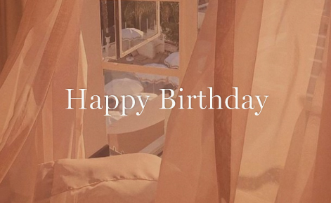 Gift card image of drapes in room blowing in the wind with a view out of the window with the text “Happy Birthday” 