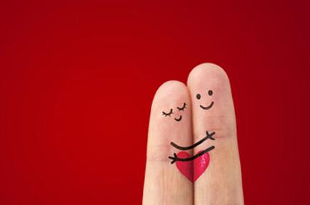 Image of two fingers with drawing of with two stick people hugging