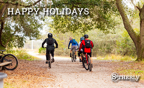 eGift Card image of family cycling through park in Tampa with the text “Happy Holidays” and the Sotherly Hotels logo