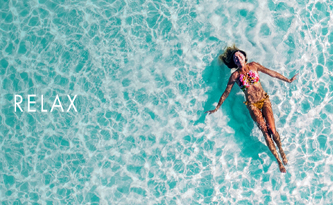 Gift card image of lady floating in the ocean with the text “Relax”