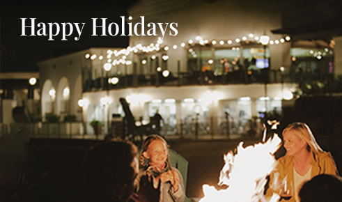 Gift card image of family sitting at the firepit at night with the text “Happy Holidays”