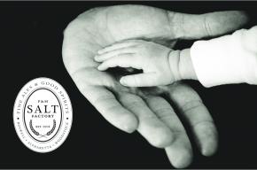 Image of a baby's hand touching an adults hand with the Salt Factory logo