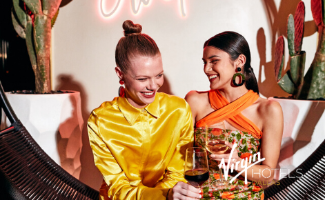 Gift card image of two ladies enjoying a cocktail with the Virgin Hotel Dallas logo