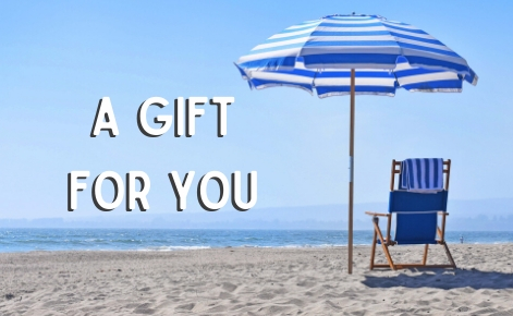 Gift card image of a deck chair and parasol on the beach with  the text “A gift For You”