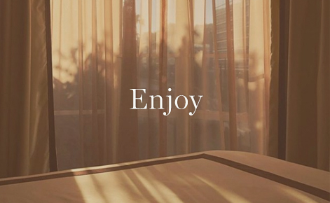 Gift card image of the sun coming through the drapes in hotel room with the text “Enjoy”