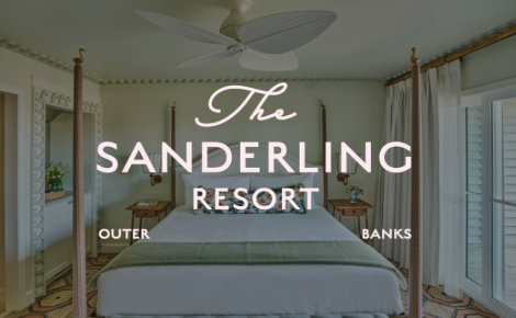 The Sanderling Resort Logo over a guest room bed. 