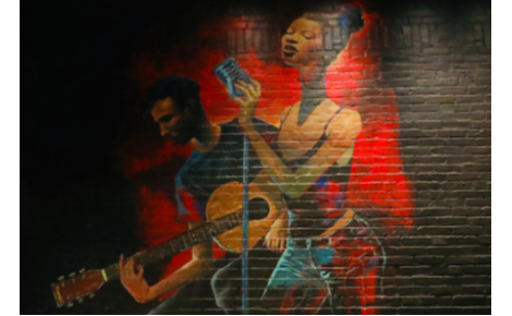 mural on a brick wall of a singer and guitar player