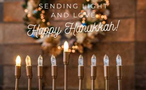 Image of a Menorah at the front desk of the hotel, with the words "Sending Light and Love: Happy Hanukkah!"