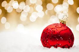 Image of red Christmas ball in front of a sparkly gold background