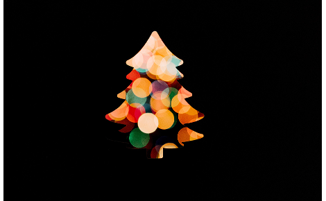 colored bokeh lights christmas tree silhouette on black background.