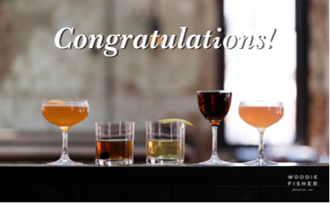 eGift card image of various cocktails lined up on the bar with the text “Congratulations!” and the Woodie Fisher Kitchen & Bar logo