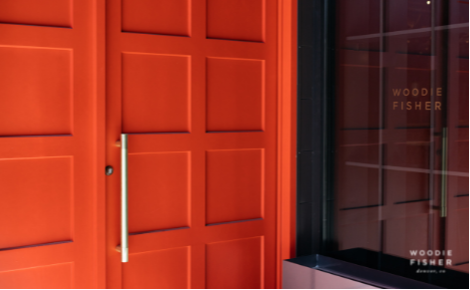 eGift card image of the entrance of the restaurant with the Woodie Fisher Kitchen & Bar logo