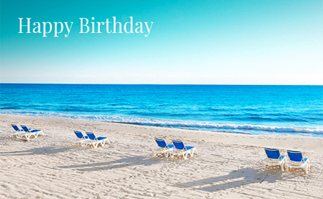 Gift card image of sun loungers on the beach with the text “Happy Birthday”