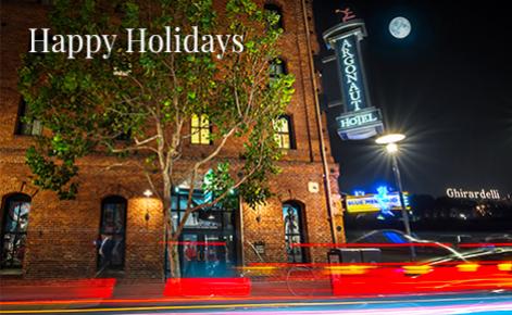 Gift card image of the exterior of the hotel at night with the text “Happy Holidays”