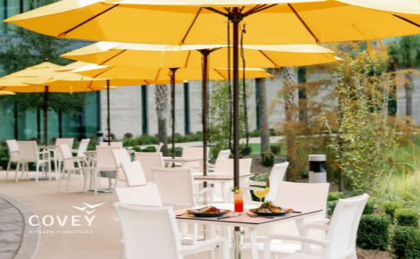 Bright yellow umbrellas provide shade over outdoor dining at Covey Kitchen + Cocktails. 